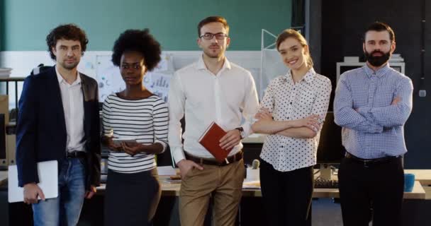 Retrato de un joven equipo de negocios multiétnicos de pie en la moderna sala de oficina. Oficinistas y trabajadoras. En interiores — Vídeos de Stock