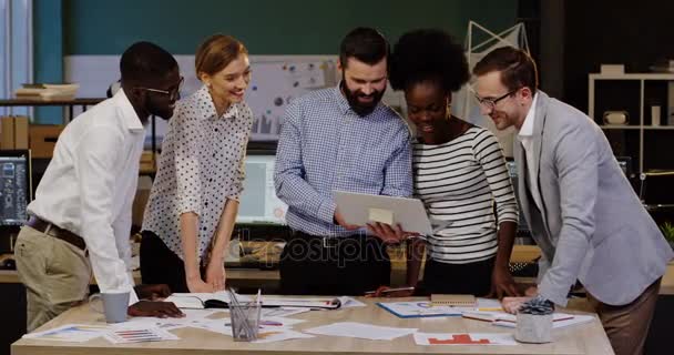 Jeune équipe multi-ethnique d'affaires ayant réussi le remue-méninges et de donner cinq à l'autre dans le bureau urbain confortable. Planification d'une start-up. Intérieur .