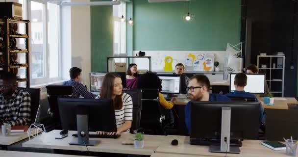 Employés de bureau masculins et féminins travaillant sur leur ordinateur. Jeune homme et femme discutant de quelque chose dans l'atmosphère moderne du bureau. Équipe commerciale .