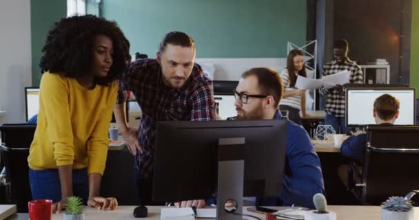 Jonge bedrijf gemengd-reed team werken aan een project op de computer. Vrouwen en mannen in het moderne kantoor. — Stockvideo