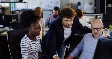 Karışık ırklar Ofis çalışanları ve bilgisayarda çalışırken iş projesi hakkında danışmanlık. Modern ofis. Kapalı.