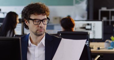 Bilgisayar başında oturan ve modern ofis Oda Yazdırılan belgelerde birlikte çalışma erkek ofis çalışanı. Kapalı