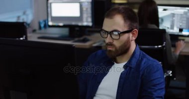 Geç saatlere kadar yorgun yakışıklı genç beyaz bir adam portresi bu ofis ve gözlüklerini alarak. Modern ofis arka plan.