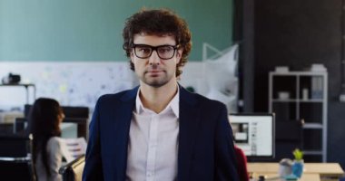 Bir gülümseme ile kameranın ve ellerinin geçiş içine işçiler ile bulanık office bilgisayar arka plan üzerinde seyir bardaklarda kıvırcık yakışıklı adam portresi. Kapalı