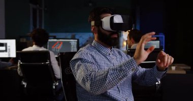 Bir Vr kulaklık onun işyerinde akşam sahip sakallı erkek ofis çalışanı. VR gözlük oturum. Modern ofis içinde