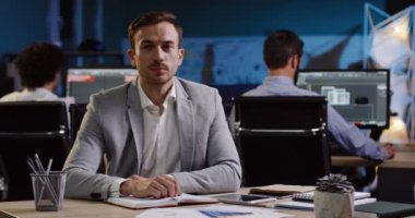 Portre sevimli adam ofis çalışanı neşeyle içine onun işyerinde ofiste kameraya gülümseyen bir kadeh. Gece geç. Kapalı. Yakın çekim