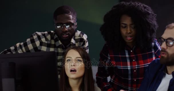 Ung trevlig multietniska kontorsarbetare att skapa en strategi för ett startup-projekt på datorn sent på kvällen. Office team av kvinnor och män i bekväma kontorslokaler. — Stockvideo