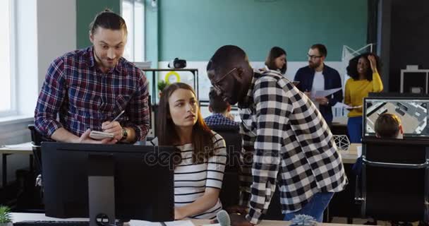 Jonge office succesvol team werken en de raadpleging over het opstarten van bedrijven op de computer in de stedelijke kantoorruimte. Mannelijke en vrouwelijke bedienden — Stockvideo