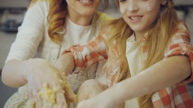 Mutlu gülümsüyor anne ve kızı bir daugh mutfakta büyük cam kapta birlikte yoğurma kapatın. Portre. Kapalı