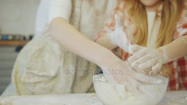 Anne ve kızı un ve daugh mutfakta oldukları için ellerini ovuşturarak pişirme ile meşgul, yakın çekim. Portre vurdu. Kapalı