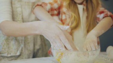 Mutlu anne ve kızı daugh ile birlikte mutfakta büyük cam kasede yumurta yoğurma kapatın. Portre. Kapalı