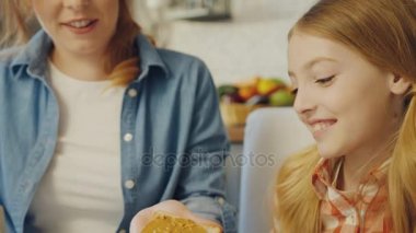 Mutlu anne ve kızı mutfakta oturuyor ve fıstık ezmesi sandviç yapmak gülümsedi. Yakın çekim. Portre. Kapalı