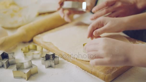 Крупним планом кавказьких жінки і діти рук робить форми від на daugh на кухонному столі. В приміщенні — стокове відео