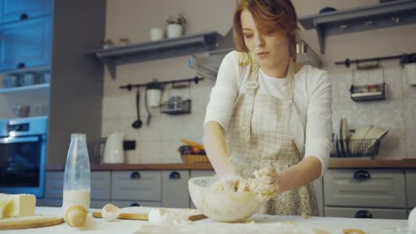 Portrat shot della donna attraente nel grembiule impastare un daugh per biscotti sul tavolo in cucina. Dentro. — Video Stock