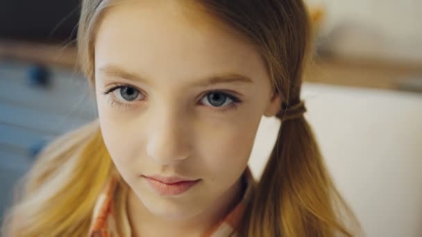 Retrato tiro da linda menina bonita adolescente com cabelo loiro longo em duas caudas olhando diretamente para a câmera. Fecha. Interior — Vídeo de Stock