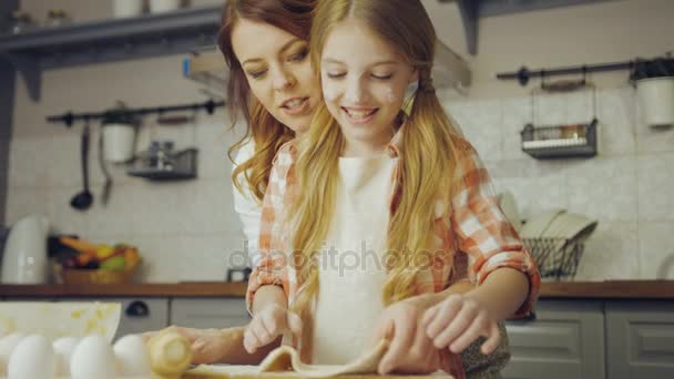 Retrato de la linda adolescente aprendiendo a hacer un daugh y su madre ayudándola. acogedora cocina agradable. En interiores — Vídeo de stock