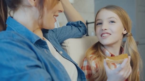 Close up da linda menina adolescente loira conversando com sua mãe bonita e segurando um pão com manteiga de amendoim. Interior — Vídeo de Stock