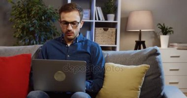 Oturma odasında yorulmaya, gözlüklerimi çıkardım alıp gözlerini biraz daha dizüstü bilgisayar üzerinde çalışan gözlüklü genç beyaz adam. Evde. Kapalı