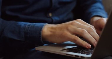 Kayıt ve tipik dizüstü bilgisayar klavye üzerinde kot gömlek erkek el kapatın. İçinde