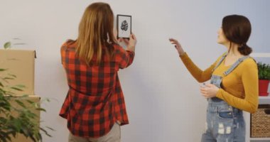 Yeni evinde taşıma ve rahat Oda açmak şeyler arasında duvarda küçük bir resim için bir yer bulmaya çalışan genç Kafkas mutlu çift. Kapalı