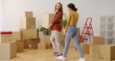 Genç Beyaz adam ve yeni dairede taşıma ve bir sürü Paketli kutuları ve iç ev malzeme getiren kadın.