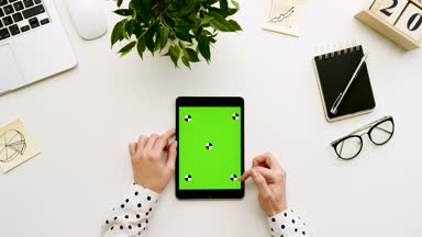 Üstten Görünüm Ofis Masası ve yeşil ekran ve eller üzerinde kayıt olan siyah tablet bilgisayar. Dikey. Yanında başı işleri. Chroma anahtar. Hareket izleme
