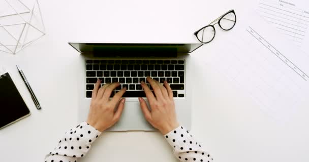 Vista superior na mesa de escritório com computador portátil com tela verde e as mãos femininas gravando sobre ele. Cadernos e óculos ao lado. Chave Chroma . — Vídeo de Stock