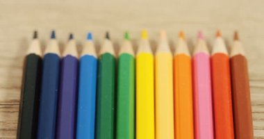 Ahşap masanın üzerinde yatan renkli kalemler kapatın. Makro