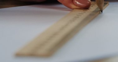 Boş kağıt üzerinde bir kalem ve bir ahşap cetvel ile bir çizgi çekerek kadının el kapatın. Makro