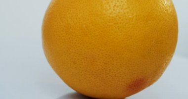 Beyaz duvar arka plan üzerinde haddeleme portakal greyfurt, makro çekim. Yakın çekim