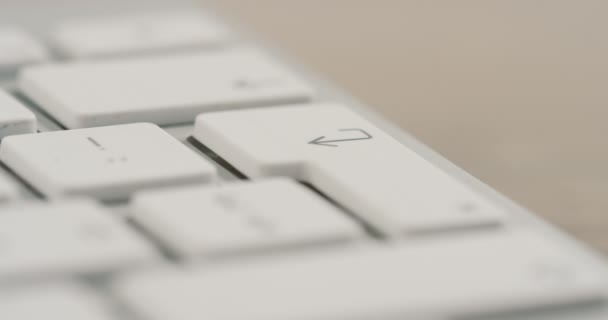 Macro de las mujeres que graban el dedo en el botón entrar en el teclado blanco. De cerca. — Vídeo de stock