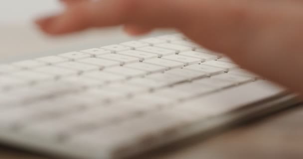 Close up of the womans hands taping and working on the white keyboard. View from the side. Macro — Stock Video