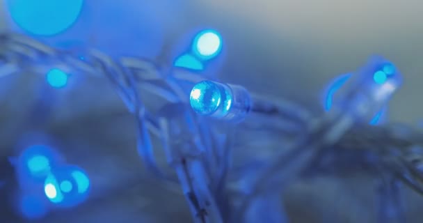 Makro på effekt bokeh med blue garland lights. Vit bakgrund. Närbild — Stockvideo