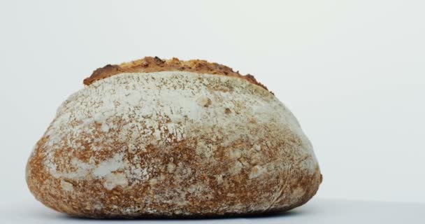 关闭的黑麦面包滚动在镜头前的白色背景。宏 — 图库视频影像