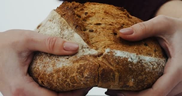 关闭的女性手分享黑麦面包在白色的背景。宏 — 图库视频影像
