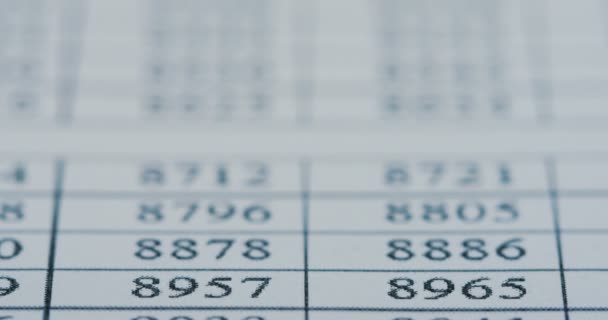 Macro van de grafiek met nummers liggen op de tabel en de marker een streep op de rij met een gele kleur. Close-up — Stockvideo