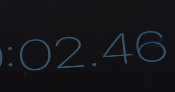 Primer plano del contador de segundos y milisegundos en la pantalla negra. Macro — Vídeo de stock