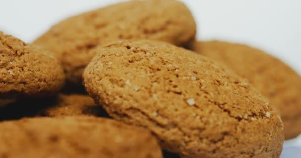 Prise de vue macro des cookies qui roulent devant la caméra sur fond blanc. Gros plan — Video