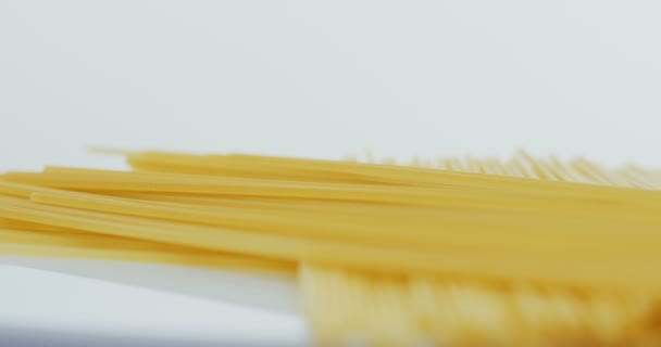 Close up of the spaghetti lying on the white background. Macro shooting — Stock Video