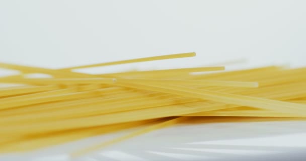 Närbild av den pasta som ligger på den vita bakgrunden. Makrofotografering — Stockvideo