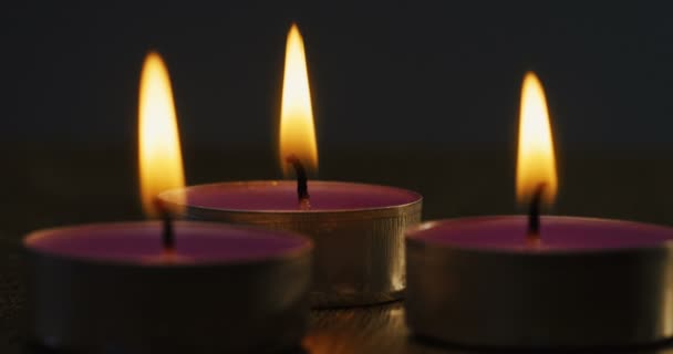 Nahaufnahme der drei Kerzen, die vor der Kamera brennen. Makroschießen — Stockvideo