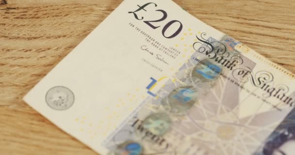 Close up of the pound bill with Queen Elizabeth lying on the wooden desk. Macro shooting — Stock Video