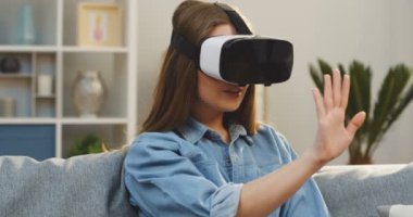 Kanepede oturan ve evde bir Vr kulaklık olan genç kadın portresi. VR gözlük. Kapalı