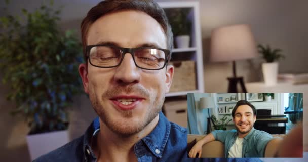自宅でコンピュータ画面上の2つの幸せな友人のグループビデオチャットのコラージュ。ビデオチャット室で話している白人の陽気な男性。ウェブカメラを通してチャットするハンサムな男性のビデオ。レジャーコンセプト — ストック動画