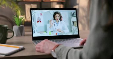 Beyaz tenli güzel kadın doktorla dezenfektan jeli hakkında online istişare yapan bir kadın. Hekim kıza bilgisayar konferansında nasıl dezenfektan kullanılacağını gösteriyor ve anlatıyor. Virüs konsepti