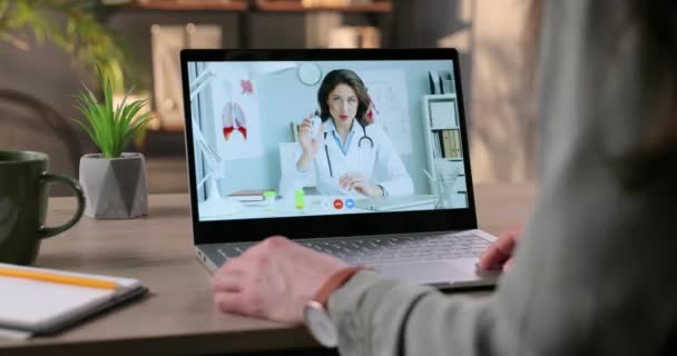 Nő online konzultáció kaukázusi csinos női orvos a fertőtlenítő gél. Az orvos bemutatja és elmagyarázza a lánynak, hogyan kell használni a fertőtlenítőt a videokonferencián a laptopon. A vírus fogalma — Stock videók