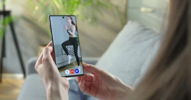 Beyaz kadın fitness eğitmeniyle görüntülü görüşme yapan kız kaslarını ısıtıyor. Kadın video konferansında spor yapan ve diz üstü atlayan bir kadınla konuşuyor. Kilitleme kavramı