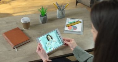 Beyaz tenli güzel kadın doktorla dezenfektan jeli hakkında online istişare yapan bir kadın. Doktor, kıza tabletteki video konferansında nasıl dezenfektan kullanılacağını gösteriyor ve anlatıyor. Virüs konsepti