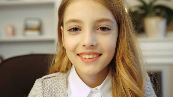 Portretul unei fetițe drăguțe care deschide ochii, se uită la cameră și zâmbește în sufragerie. Close up . — Fotografie, imagine de stoc