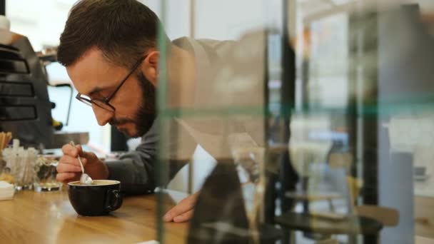 スタイリッシュなコーヒーの新鮮なコーヒーを嗅ぐ眼鏡に髭を生やしたヒップスター白人バリスタの肖像. — ストック動画